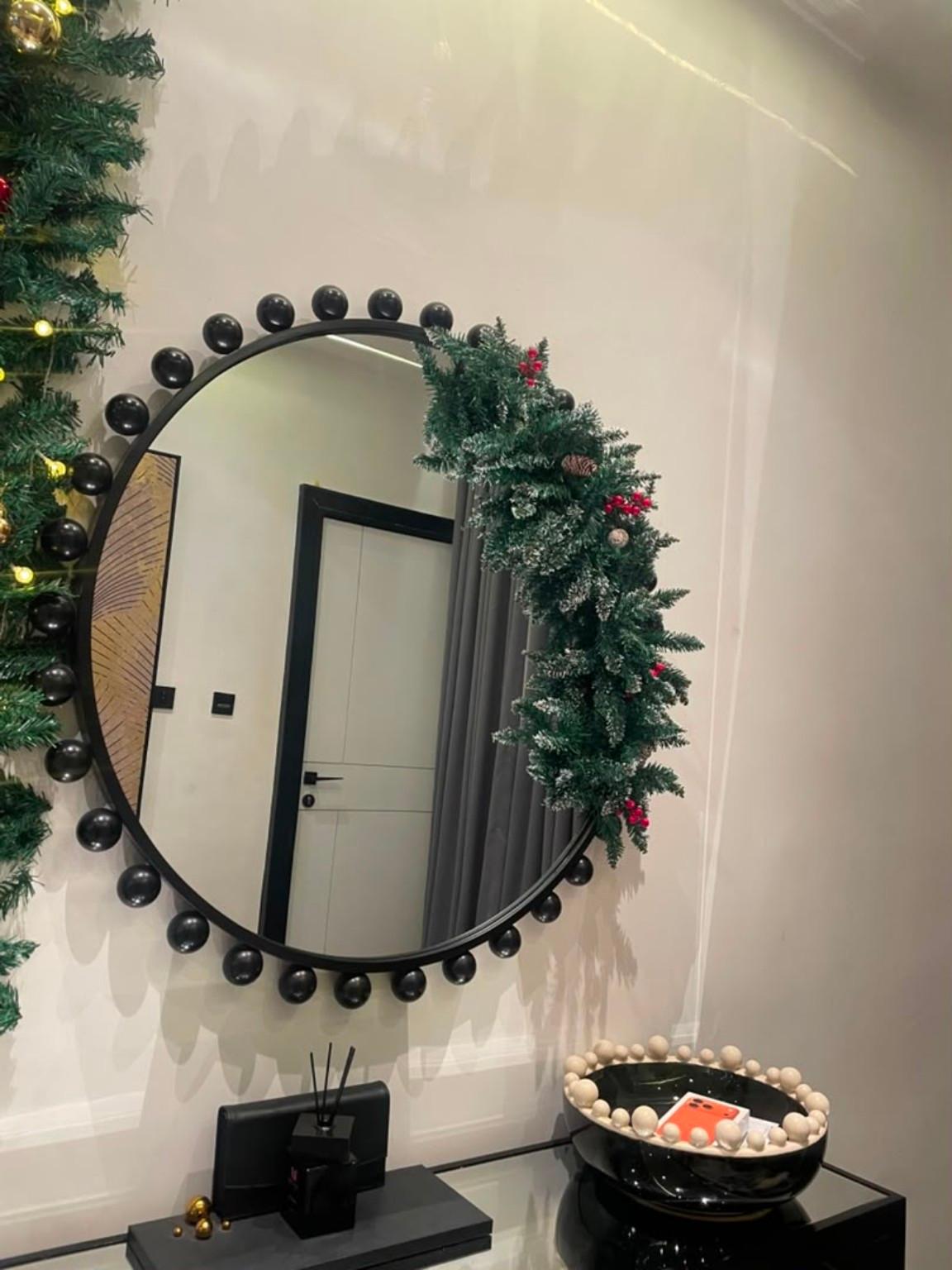 Christmas garland framing a circular mirror