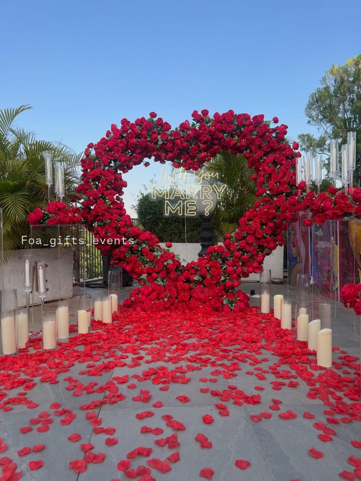 Red petal aisle leading to an outdoor floral heart